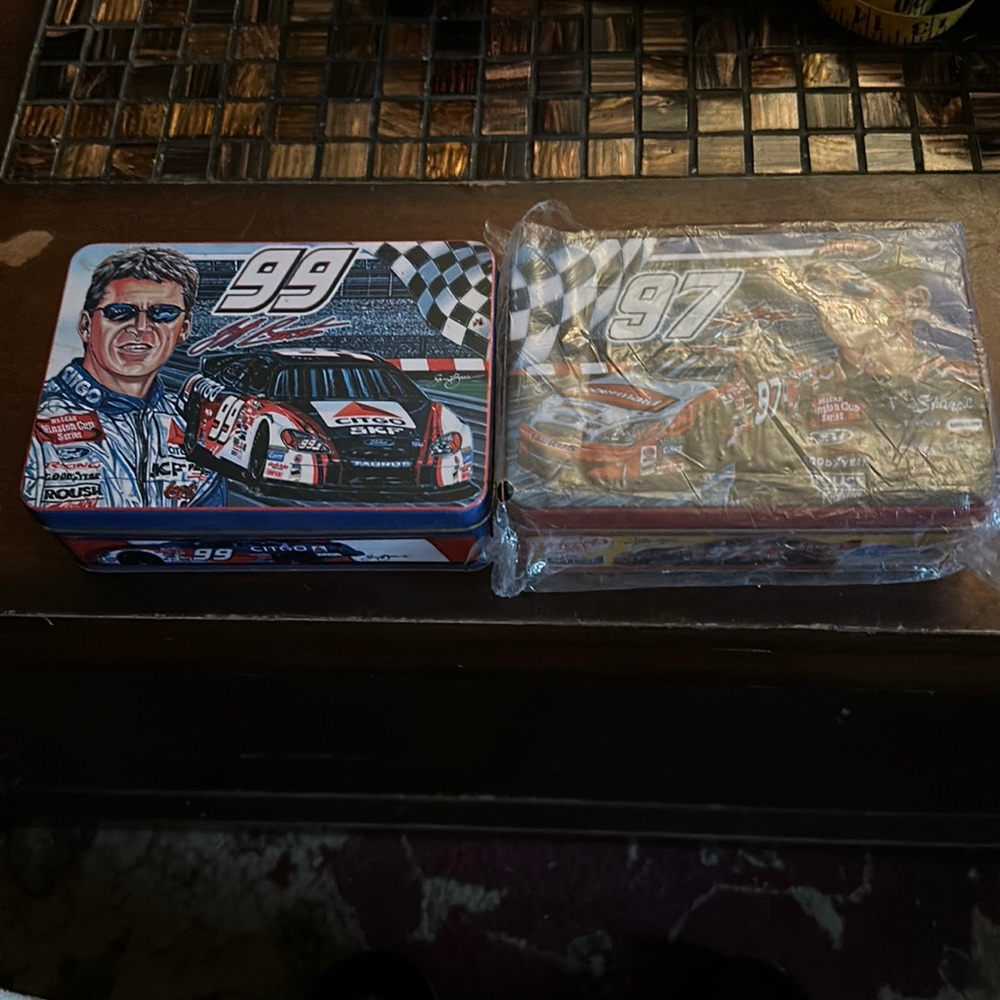 Two racing tins number 97and 99 one new in plastic other out of plastic